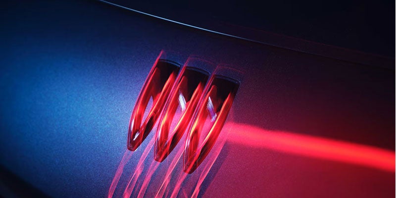 Three red illuminated vertical slats on a dark textured surface