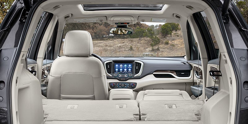 View from the rear cargo area of a GMC SUV showing a beige interior