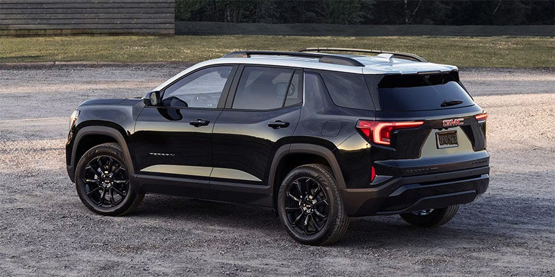 Black GMC SUV shown from a rear three-quarter angle, parked on a gravel surface